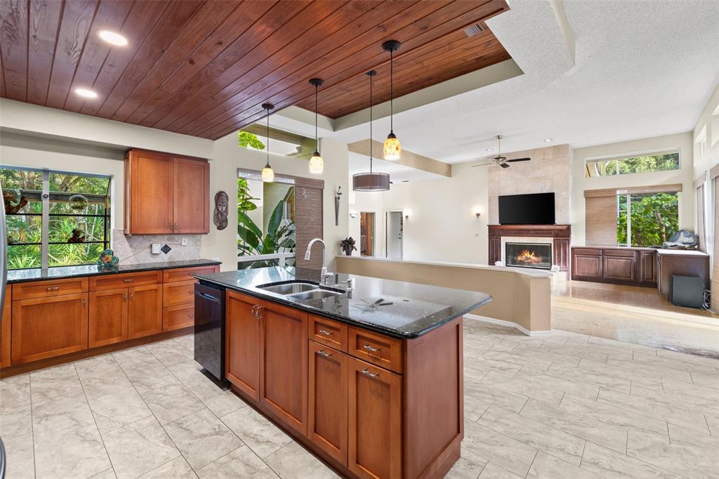 1343 Ranchero Drive Sarasota, FL 34240 - Photo 36 of 68 a kitchen with stainless steel appliances granite countertop wooden cabinets a sink and a large window