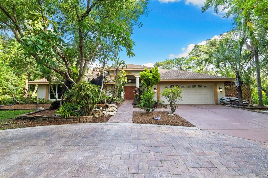 1343 Ranchero Drive Sarasota, FL 34240 - Photo 10 of 68 a view of a house with potted plants and large trees
