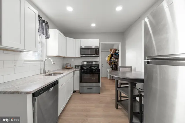 a kitchen with a stove a sink and a refrigerator