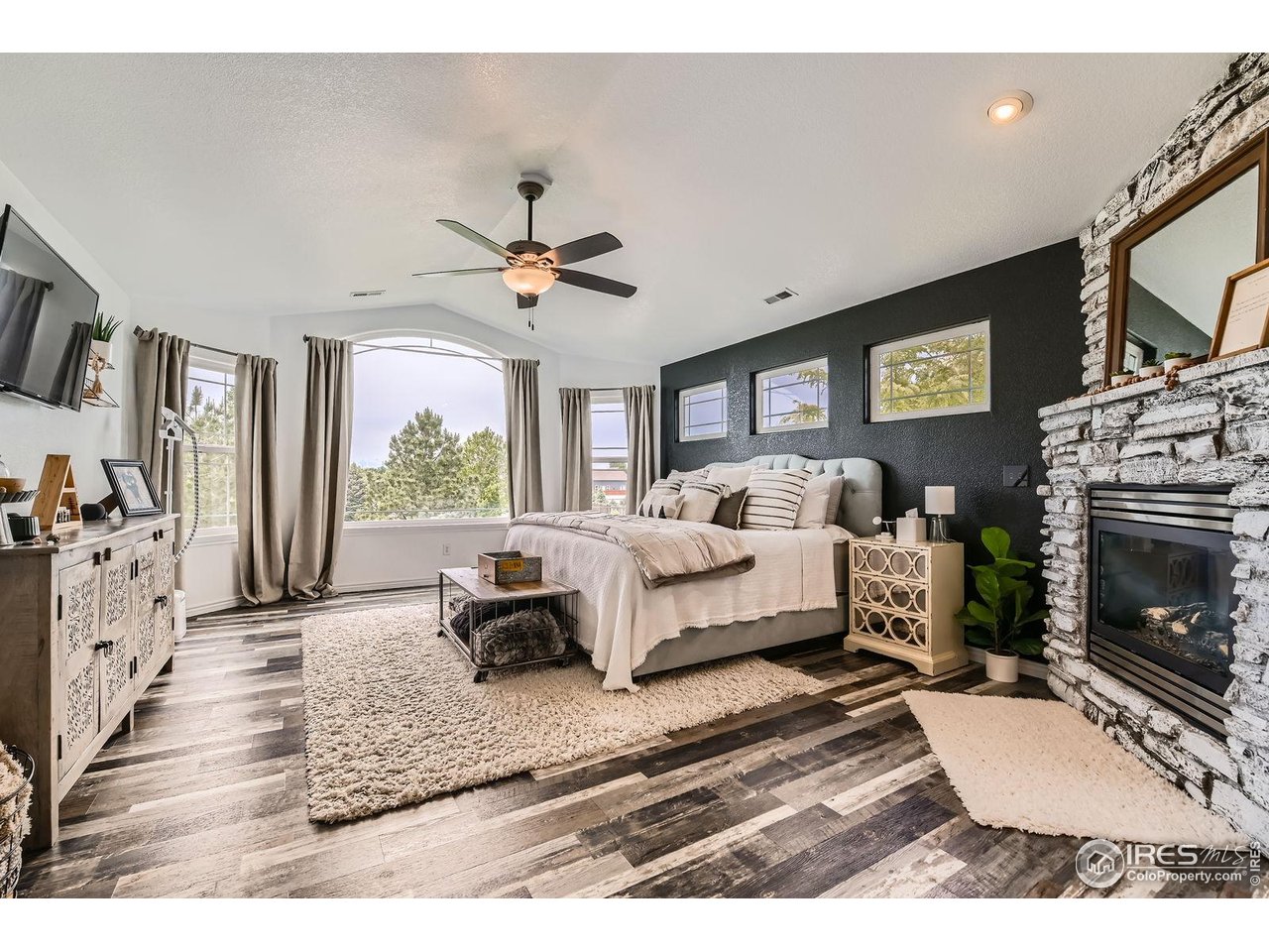8839 Shetland Drive Frederick, CO 80504 - Photo 20 of 40 a living room with furniture a fireplace and a flat screen tv