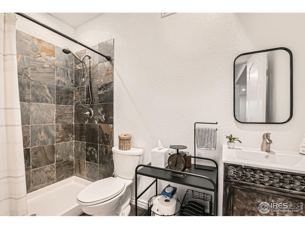 8839 Shetland Drive Frederick, CO 80504 - Photo 33 of 40 a bathroom with a sink a toilet and shower