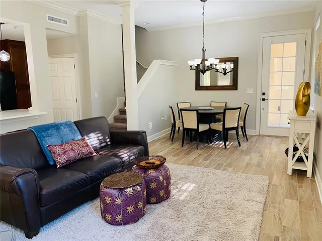 a living room with furniture a dining table and a flat screen tv