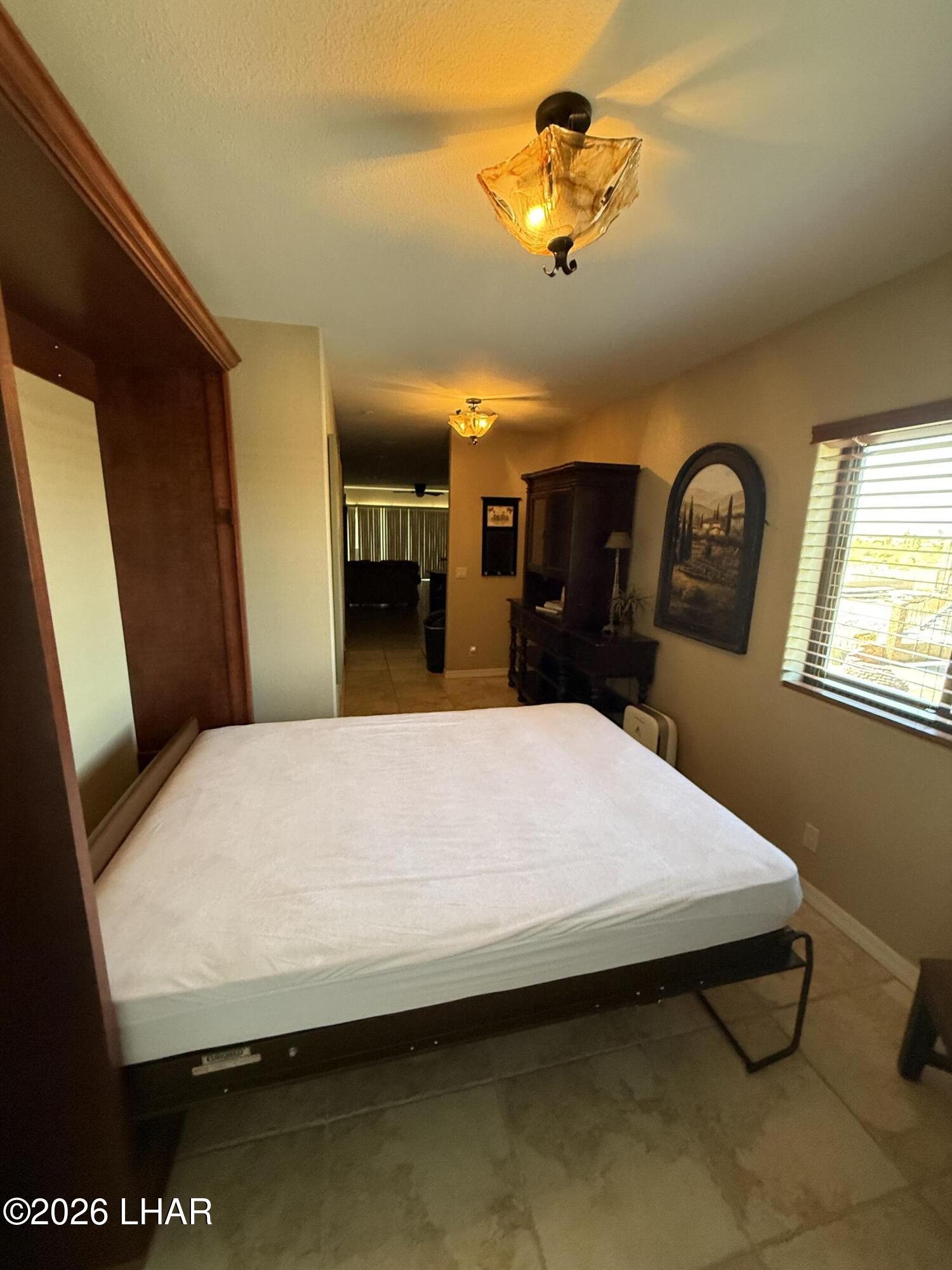 433 London Bridge Road, Unit B101 Lake Havasu City, AZ 86403 - Photo 11 of 35 a bed sitting in a spacious bedroom next to a window