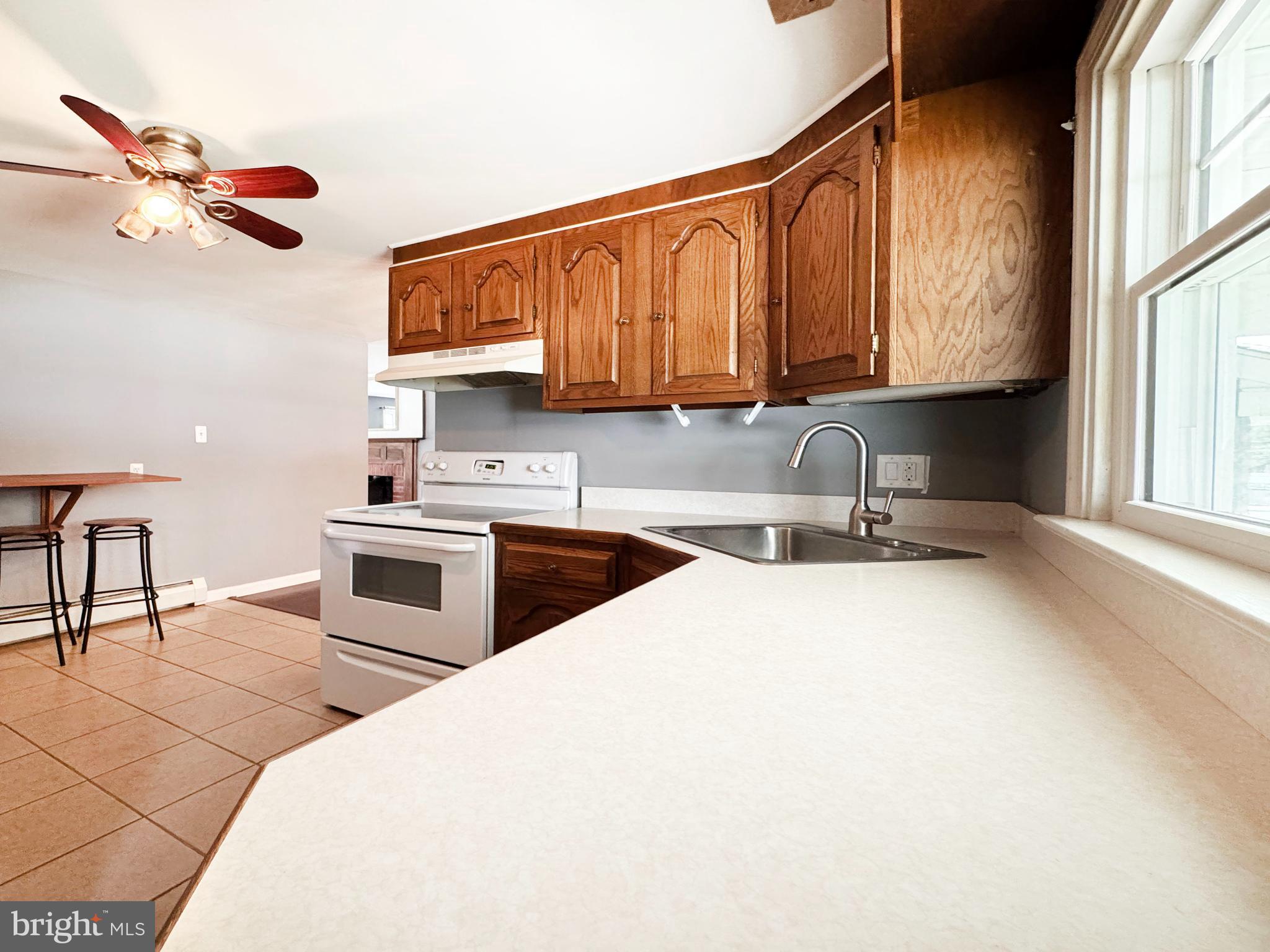 1228 Clyde Road Warminster, PA 18974 - Photo 7 of 19 a kitchen with stainless steel appliances a sink a stove a refrigerator cabinets and a window