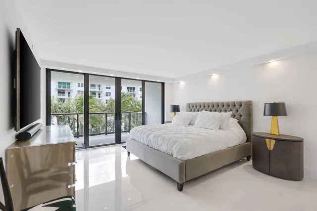 a spacious bedroom with a bed and large windows