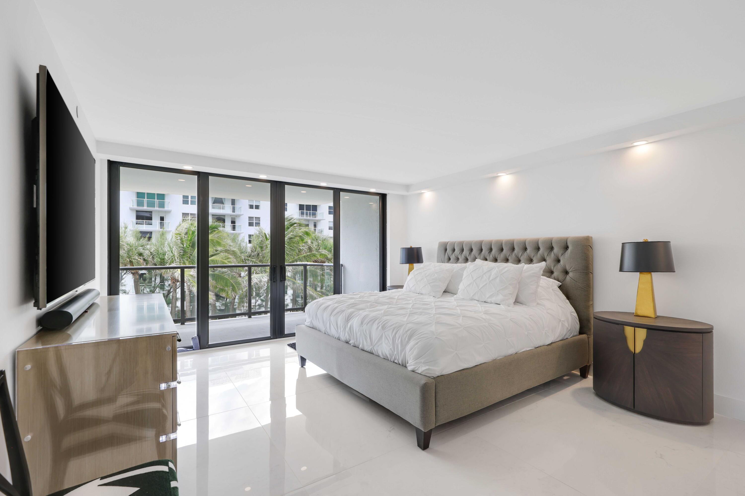 3440 South Ocean Boulevard, Unit 402S Palm Beach, FL 33480 - Photo 13 of 33 a spacious bedroom with a bed and large windows