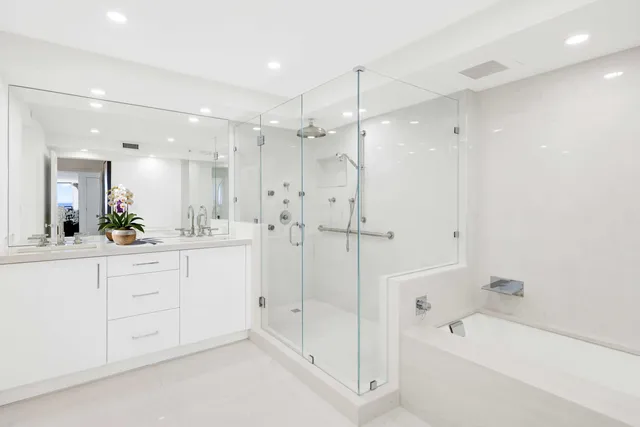 a bathroom with a bathtub shower sink vanity and mirror
