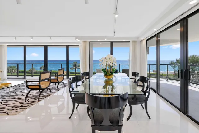 a dining room with furniture a floor to ceiling window and wooden floor