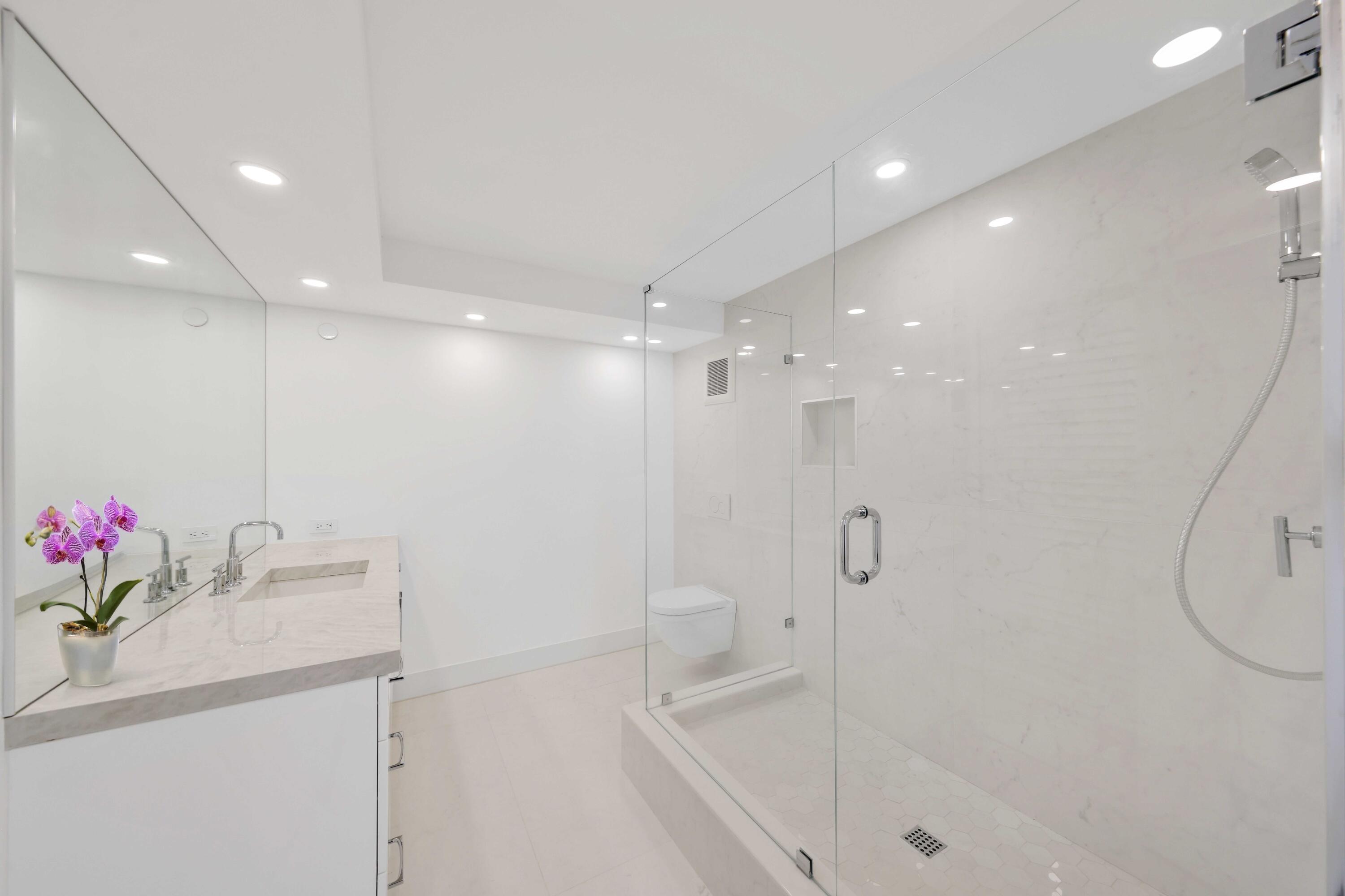 3440 South Ocean Boulevard, Unit 402S Palm Beach, FL 33480 - Photo 21 of 33 a bathroom with a shower sink vanity and mirror