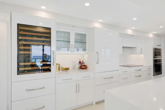 a kitchen with white cabinets and window