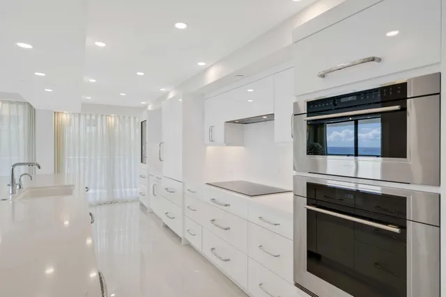 a kitchen with stainless steel appliances kitchen island granite countertop a stove and a sink