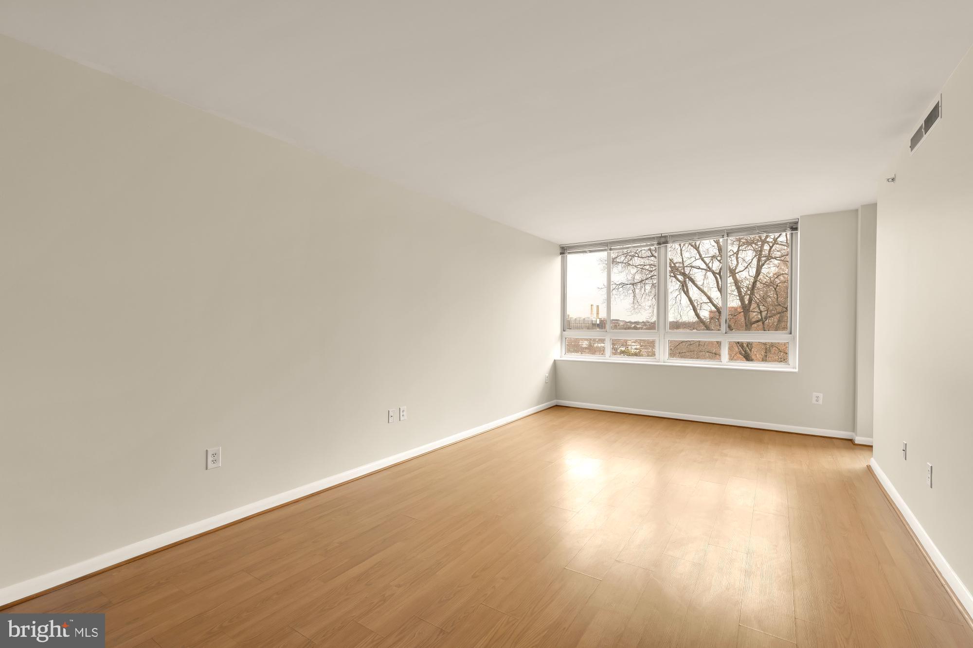 355 I Street Southwest, Unit 621 Washington, DC 20024 - Photo 20 of 34 an empty room with wooden floor and windows