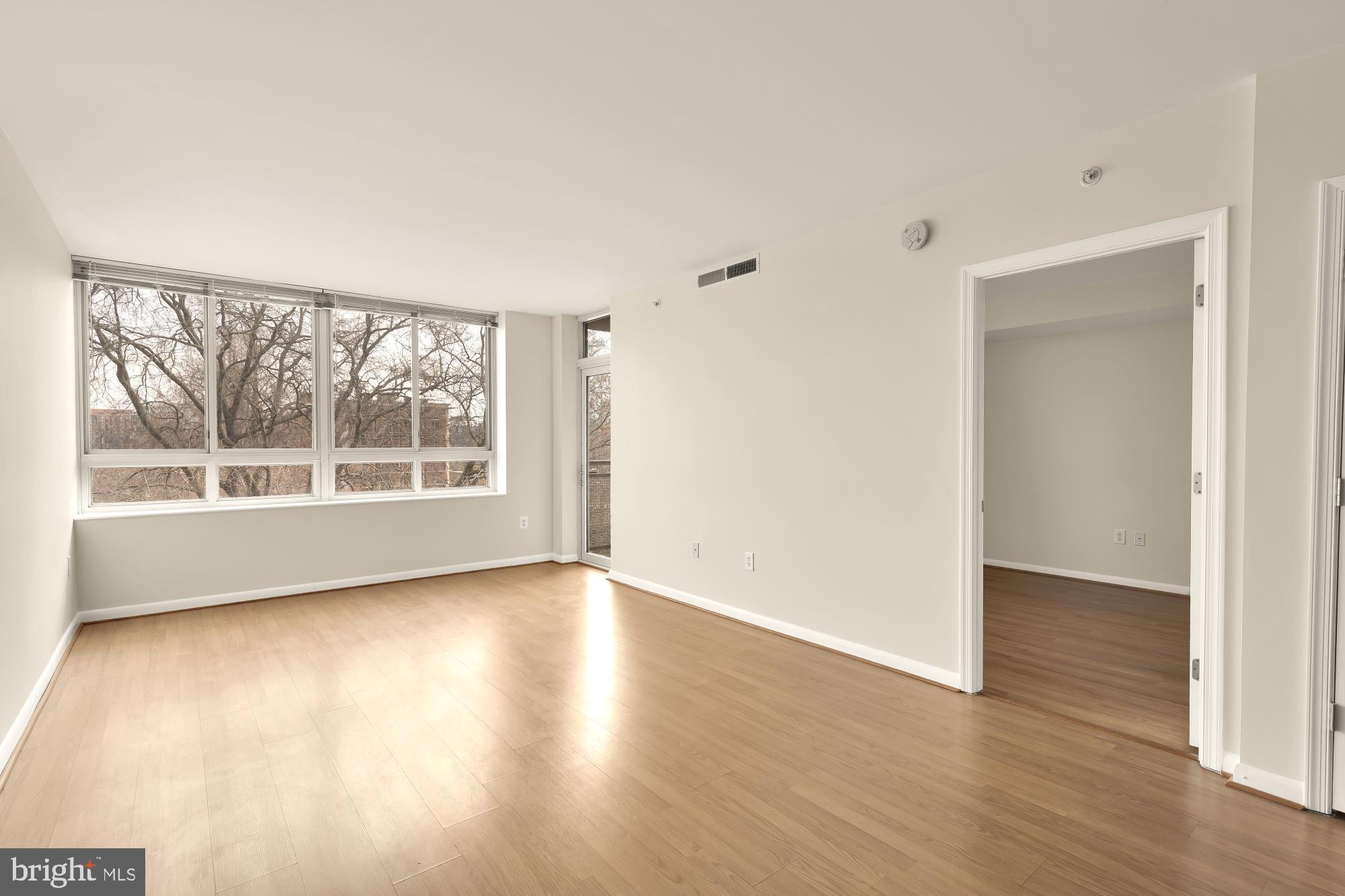 355 I Street Southwest, Unit 621 Washington, DC 20024 - Photo 21 of 34 an empty room with wooden floor and windows