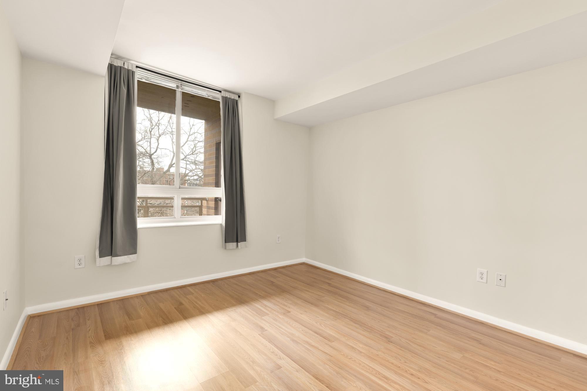 355 I Street Southwest, Unit 621 Washington, DC 20024 - Photo 29 of 34 an empty room with wooden floor and windows