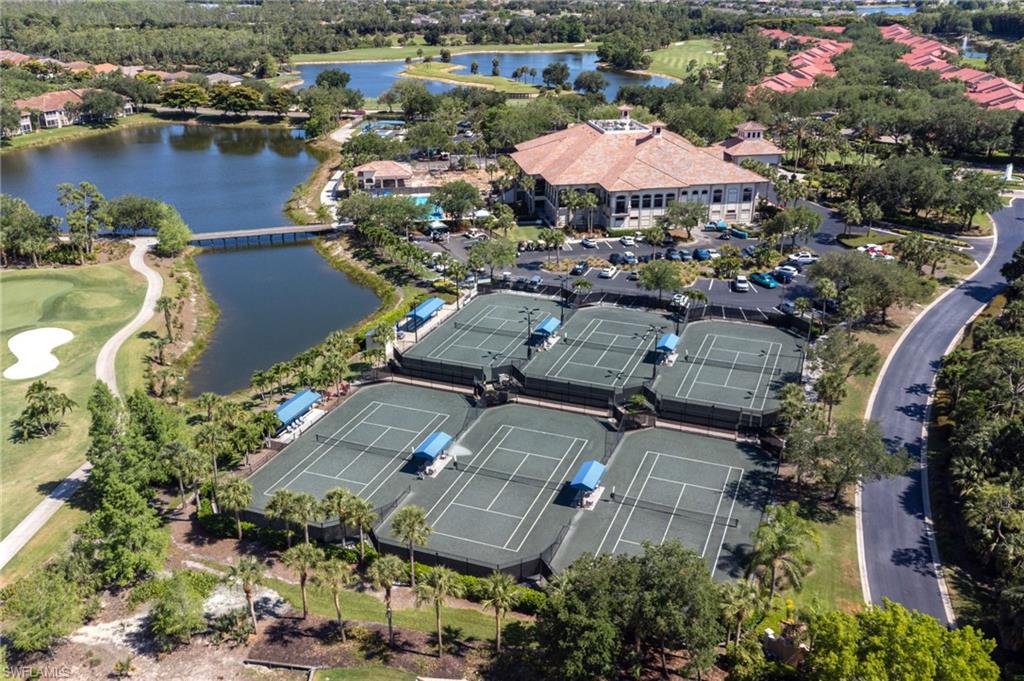 20117 Seadale Court Estero, FL 33928 - Photo 27 of 34 Extensive tennis court facility, a substantial building with a tile roof, a serene body of water with a bridge, a golf course, and mature trees