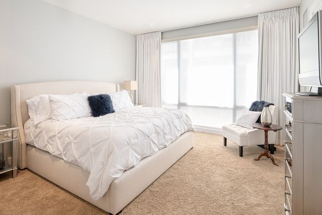 a bedroom with a bed and large window
