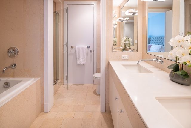 a spacious bathroom with a tub sink and mirror