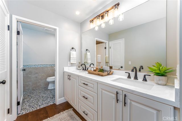 a bathroom with a granite countertop sink mirror vanity and toilet