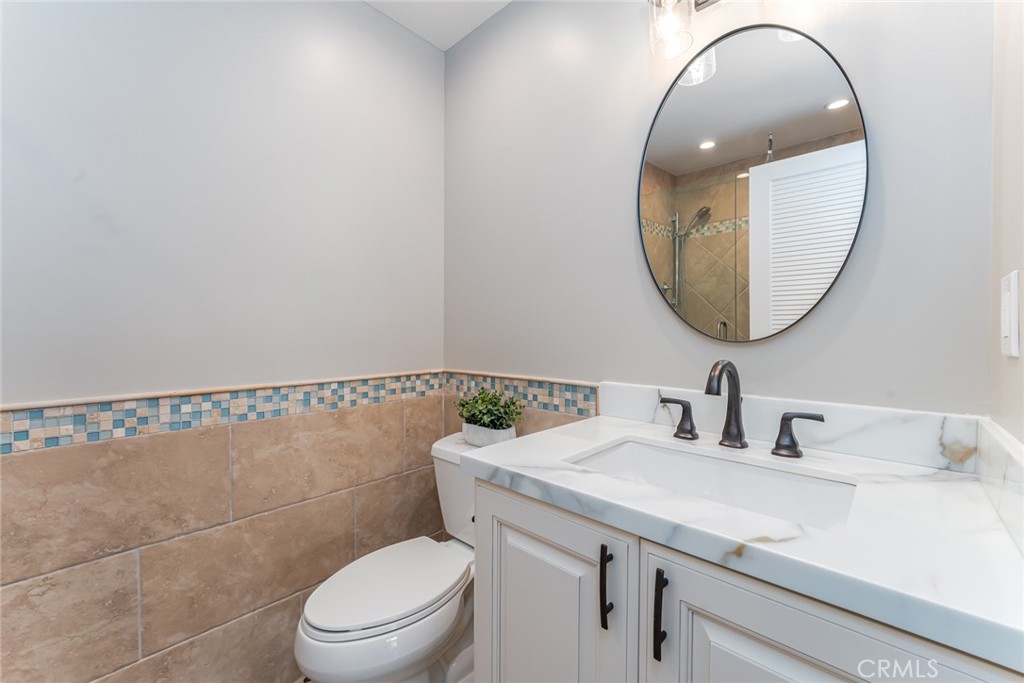 22058 Arrowhead Lane Lake Forest, CA 92630 - Photo 26 of 62 a bathroom with a toilet a sink a mirror and a toilet