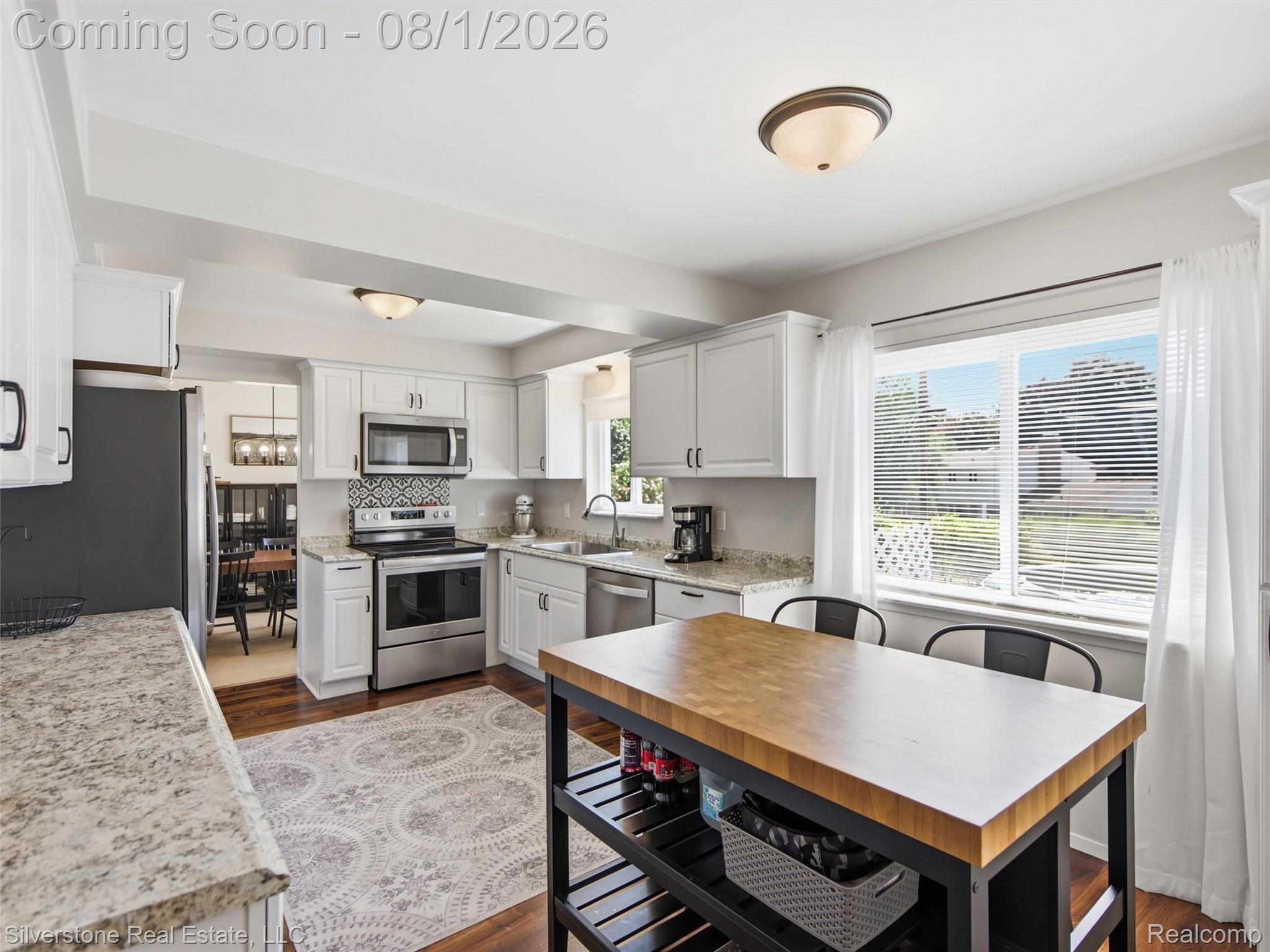2135 Wayward Drive Rochester, MI 48309 - Photo 14 of 55 Contemporary kitchen featuring white cabinetry, stainless steel appliances, granite countertops, patterned tile backsplash, and wood-finish flooring