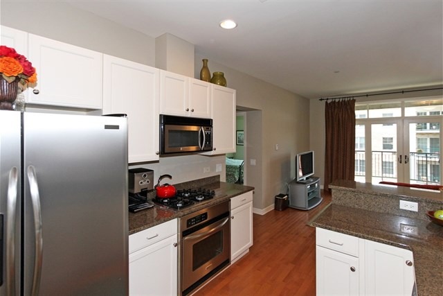 151 West Wing Street, Unit 610 Arlington Heights, IL 60005 - Photo 12 of 21 a kitchen with granite countertop a refrigerator stove and sink