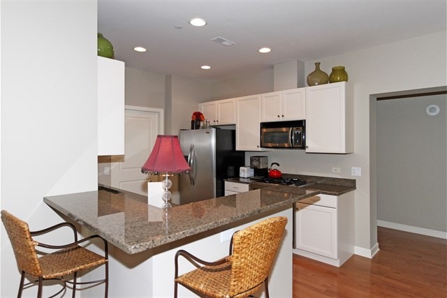 151 West Wing Street, Unit 610 Arlington Heights, IL 60005 - Photo 13 of 21 a kitchen with a dining table chairs and a refrigerator