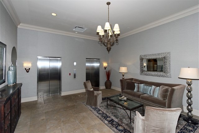 151 West Wing Street, Unit 610 Arlington Heights, IL 60005 - Photo 3 of 21 a view of a livingroom with a couch wooden floor and a chandelier