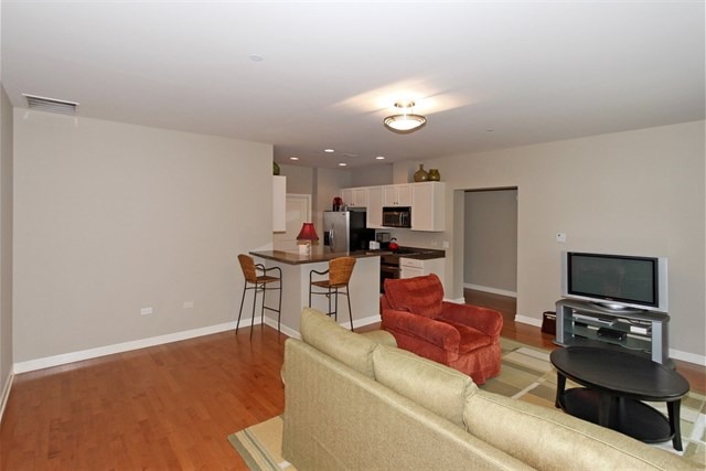 151 West Wing Street, Unit 610 Arlington Heights, IL 60005 - Photo 8 of 21 a living room with furniture and a flat screen tv