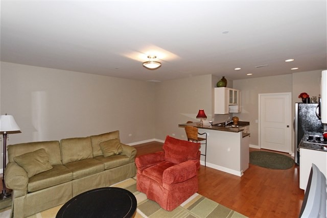 151 West Wing Street, Unit 610 Arlington Heights, IL 60005 - Photo 9 of 21 a living room with furniture a ceiling fan and a rug