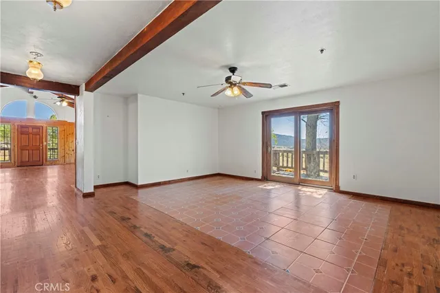 a view of a big room with wooden floor and windows
