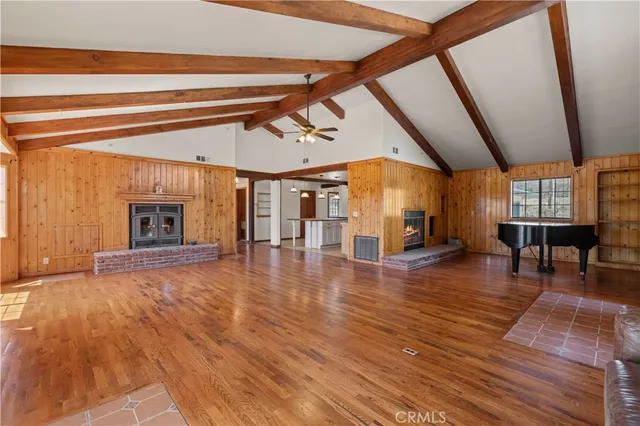a view of empty room with wooden floor and windows
