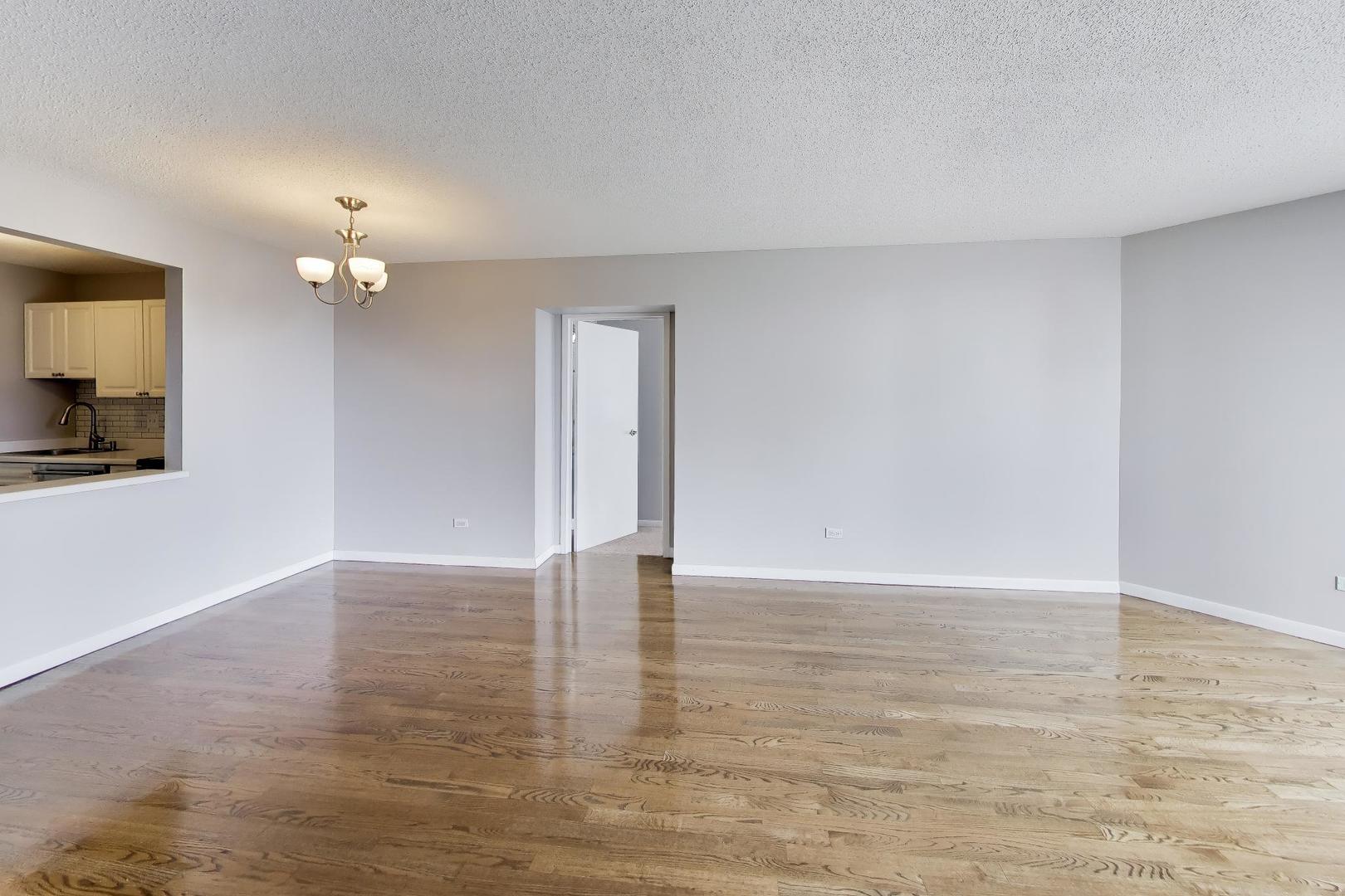 111 West Maple Street, Unit 1503 Chicago, IL 60610 - Photo 13 of 39 a view of an empty room with window and wooden floor