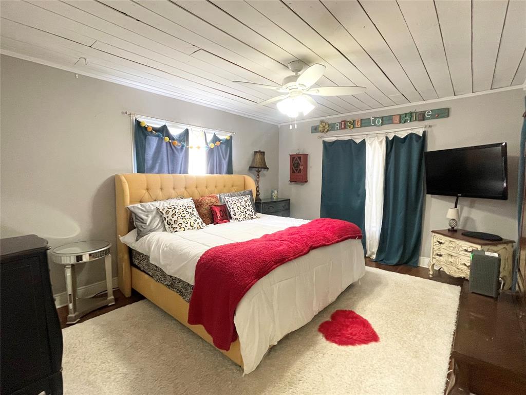 1208 Carolina Street Graham, TX 76450 - Photo 12 of 25 a bedroom with a bed and a flat screen tv