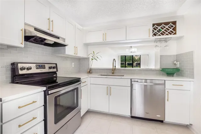 a kitchen with cabinets stainless steel appliances and wooden floor