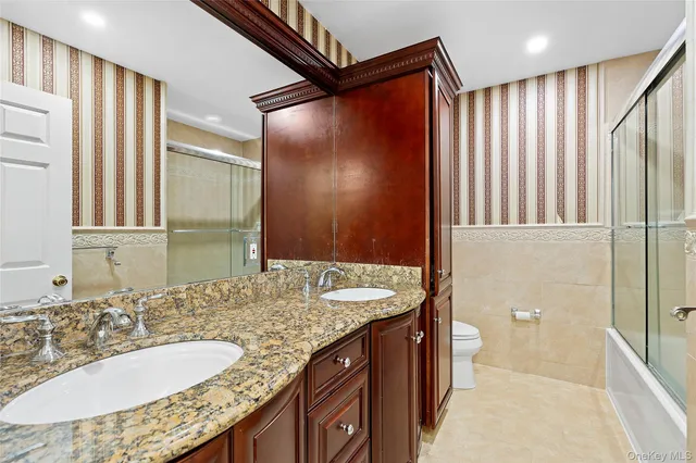 a bathroom with a granite countertop sink a mirror and a shower