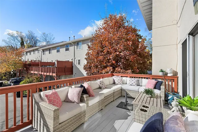 a balcony with wooden floor stairs and furniture