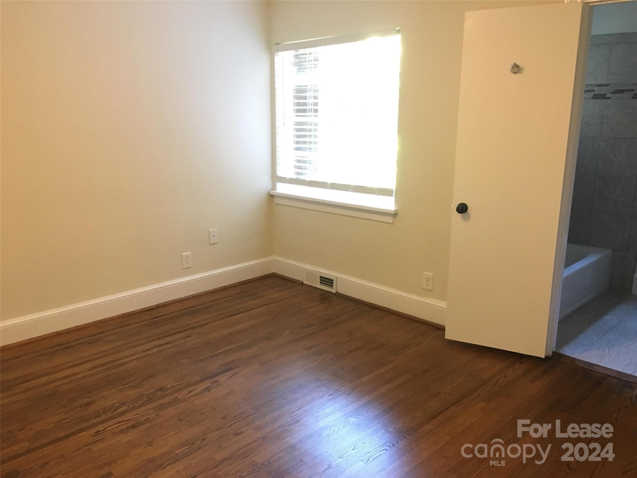 1708 Dilworth Road West, Unit 8 Charlotte, NC 28203 - Photo 11 of 15 an empty room with wooden floor and windows