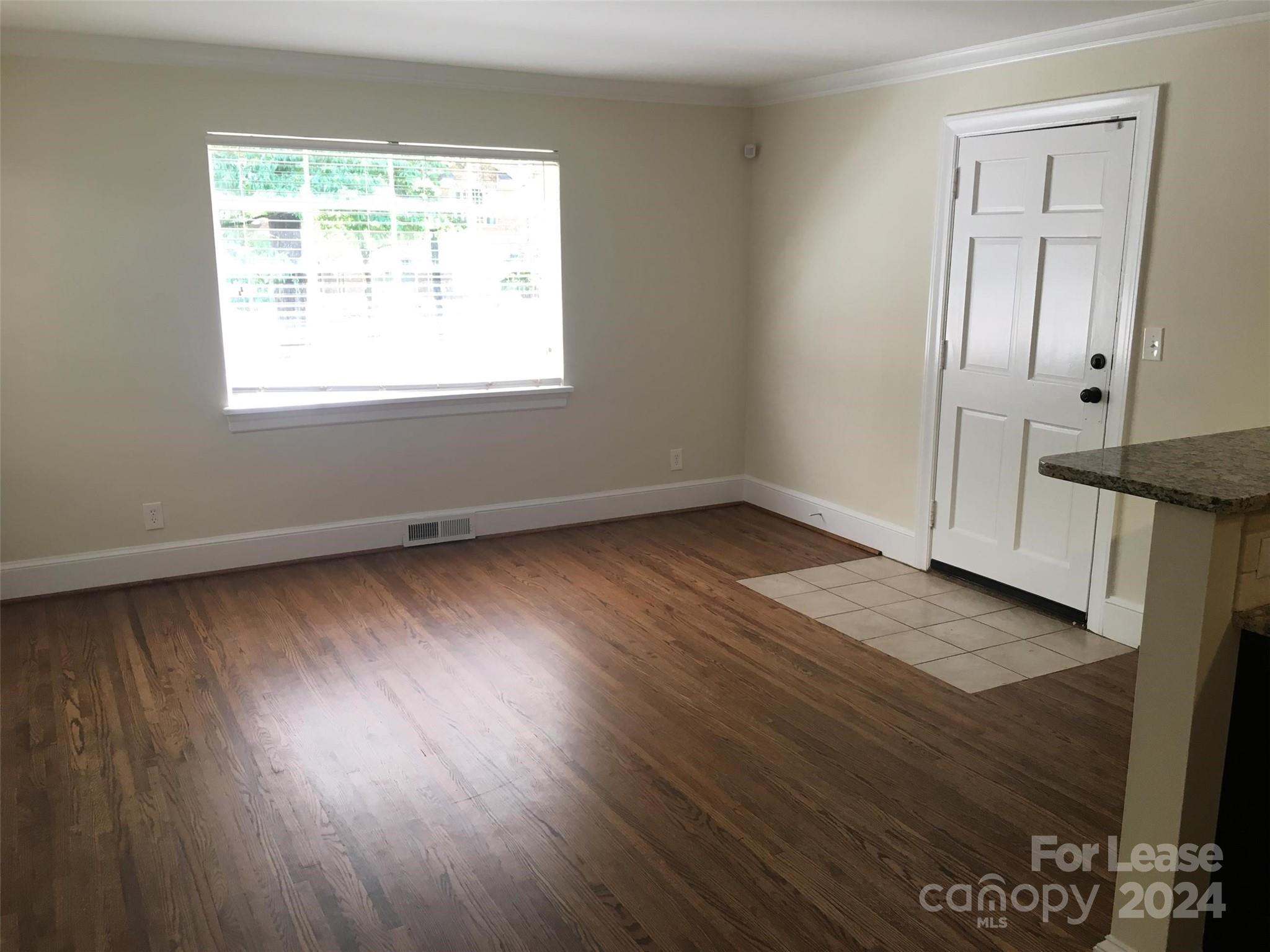 1708 Dilworth Road West, Unit 8 Charlotte, NC 28203 - Photo 3 of 15 a view of an empty room with wooden floor and a window