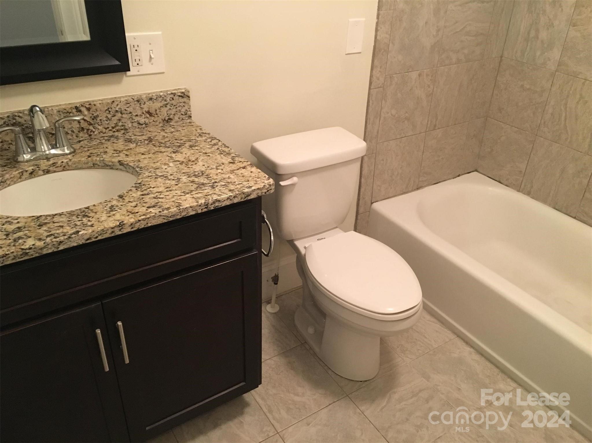 1708 Dilworth Road West, Unit 8 Charlotte, NC 28203 - Photo 8 of 15 a bathroom with a granite countertop toilet sink and mirror