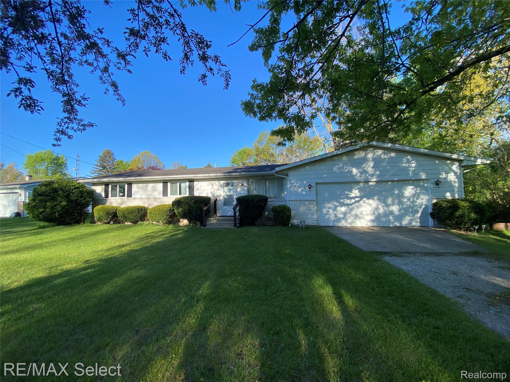 6169 Johnson Road Flushing, MI 48433 - Photo 26 of 28 Ranch-style house with concrete driveway, a garage, and a front lawn