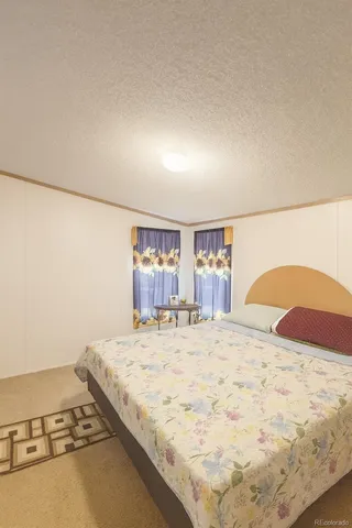 a large bedroom with a bed and a large mirror on the dresser