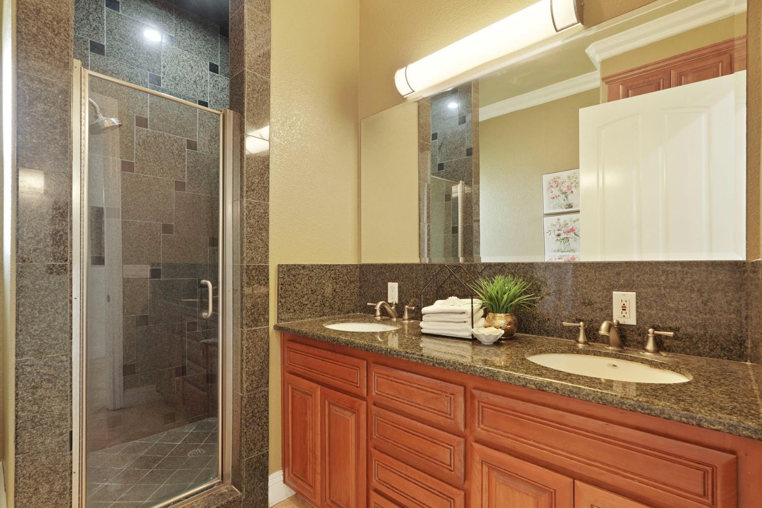 7306 Van Allen Road Stockton, CA 95215 - Photo 48 of 87 a bathroom with a granite countertop sink and a mirror