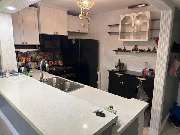a kitchen with a sink a stove and cabinets