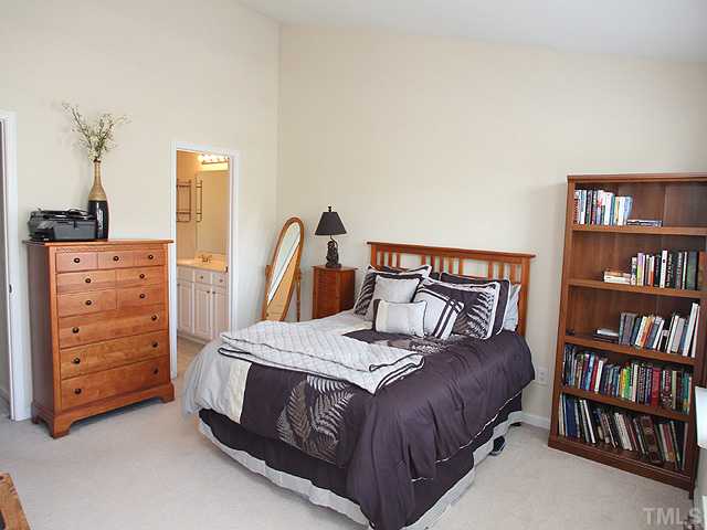 7813 Silverthread Lane Raleigh, NC 27617 - Photo 6 of 25 a bedroom with a bed a dresser and book shelf