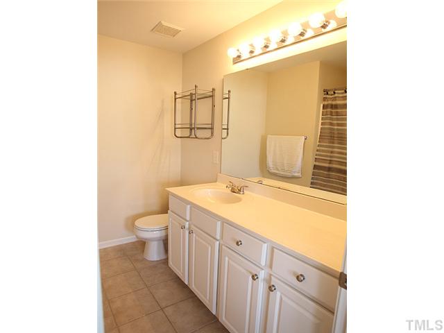 7813 Silverthread Lane Raleigh, NC 27617 - Photo 7 of 25 a bathroom with a sink a toilet and mirror