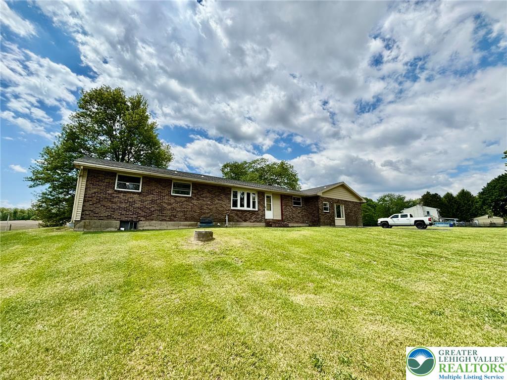 This ranch-style home features classic brick construction and expansive green surroundings.