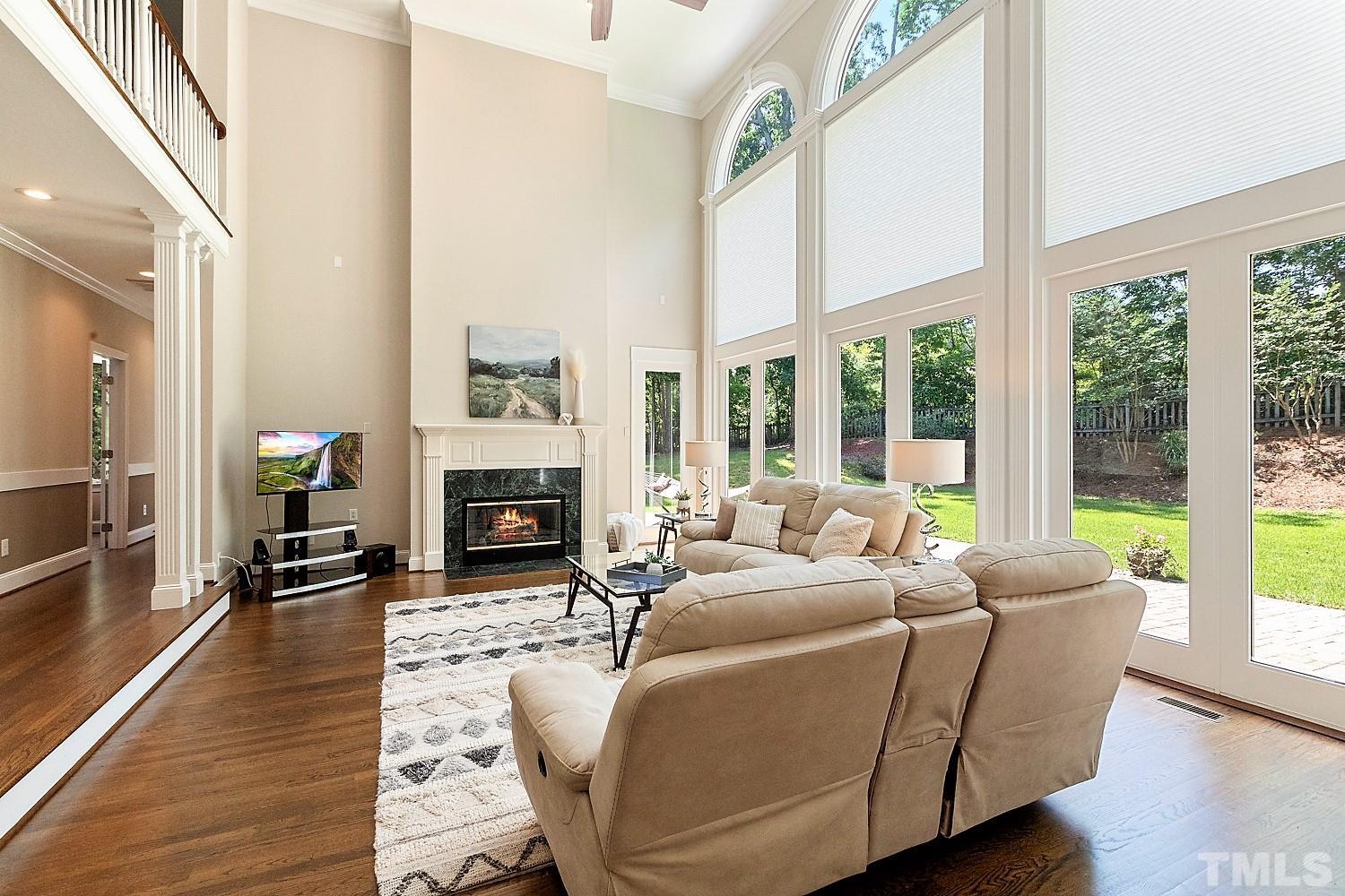100 Greyfriars Lane Cary, NC 27518 - Photo 15 of 71 a living room with furniture a fireplace and wooden floor