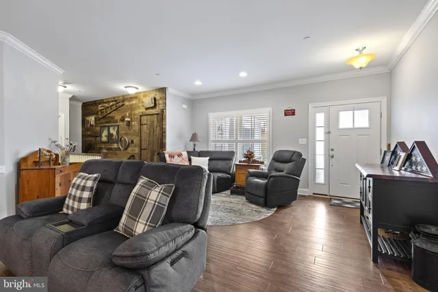 a living room with furniture a rug potted plant and a window