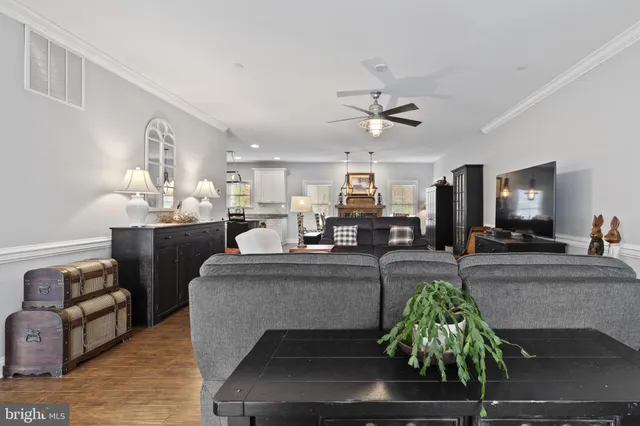 a view of a dining room and livingroom with furniture wooden floor a rug a chandelier