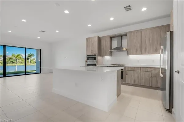 a kitchen with stainless steel appliances granite countertop a refrigerator and a stove